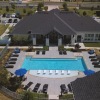 resort style pool with seating with a building behind it